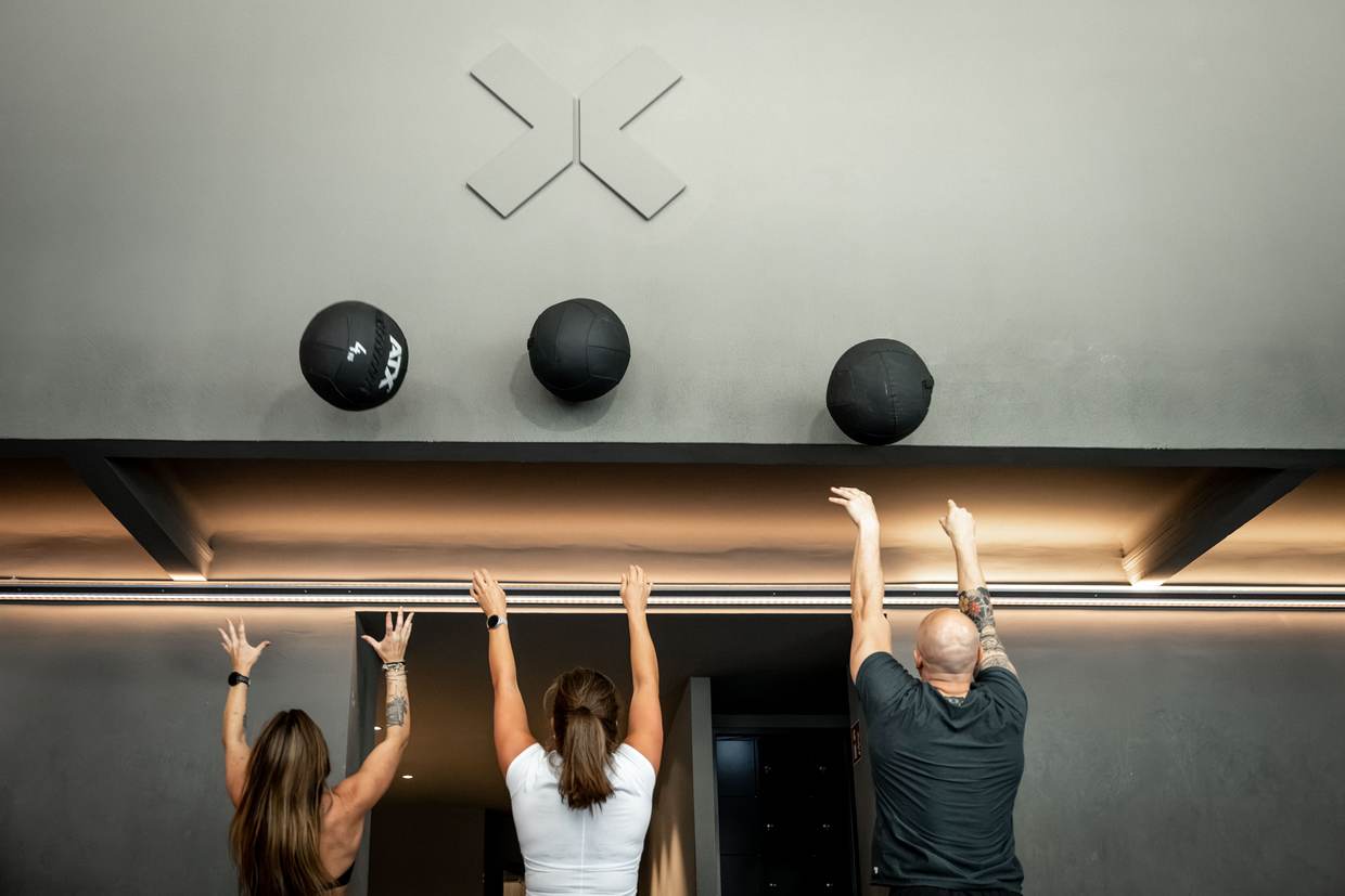 Drei Athlet:innen werfen Wall Balls an die Wand mit dem ZONE-X